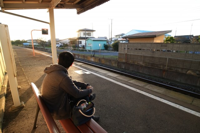 駅のベンチに座っている人